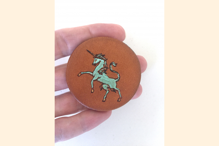 Scottish Unicorn Leather Magnet Held with Three fingers in hand to show scale