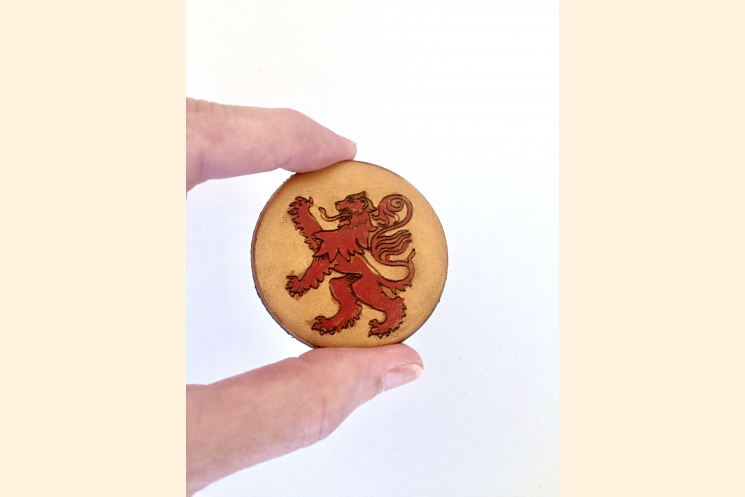 Red Rampant Lion Magnet Held with Thumb and Forefinger to Show Scale