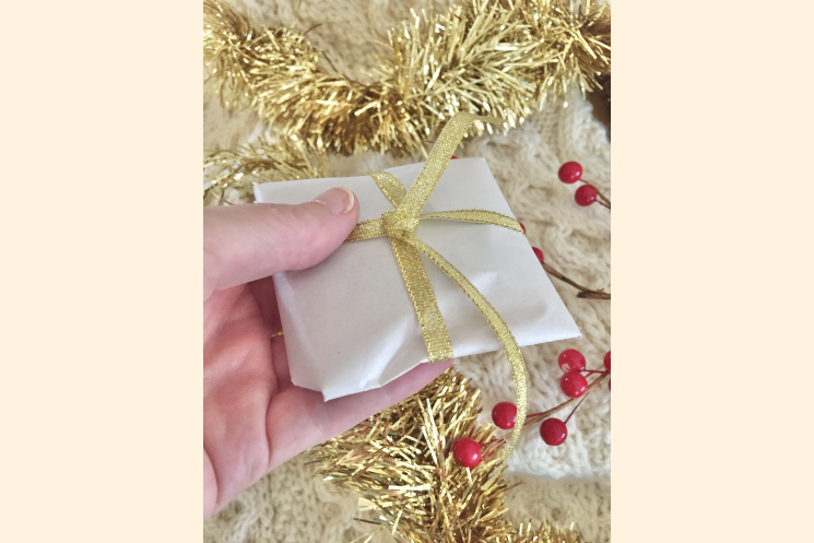 Leather Magnet Gift wrapped Shown in Hand for Scale with Holiday Background