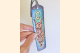Blue Celtic Owl Bookmark with Tassel held with hand for scale